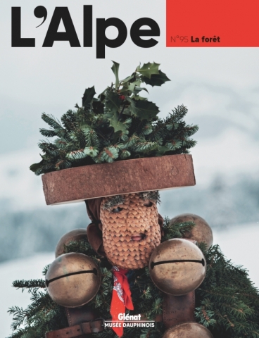 Page de couverture de L'Alpe N°95 | La forêt (personnage couvert de brachages, de cones de pin et de sonnailles)