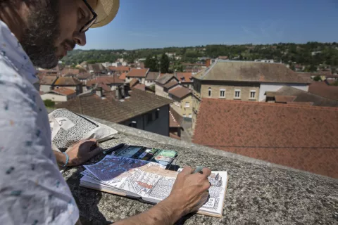 Le dessinateur Emdé croquant la Tour-du-Pin depuis le parvis de l'église © Stéphanie Nelson