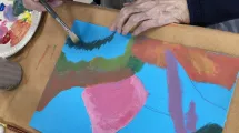 Atelier en EHPAD © CHUGA zoom sur les mains d'une personne agée peignant sur une feuille posée sur une table © CHUGA