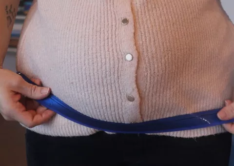 ventre de femme enceinte ceinturé par une ruban bleu © Collectif Fusées - Laura Toslli