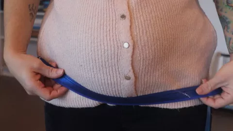 ventre de femme enceinte ceinturé par une ruban bleu © Collectif Fusées - Laura Toslli