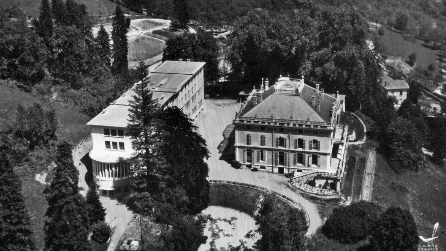 Vue générale du site vers 1960 ; la demeure transformée en maison patronale (actuellement mairie de Tullins) et le collège © Fonds Meyer, Patrimoine culturel