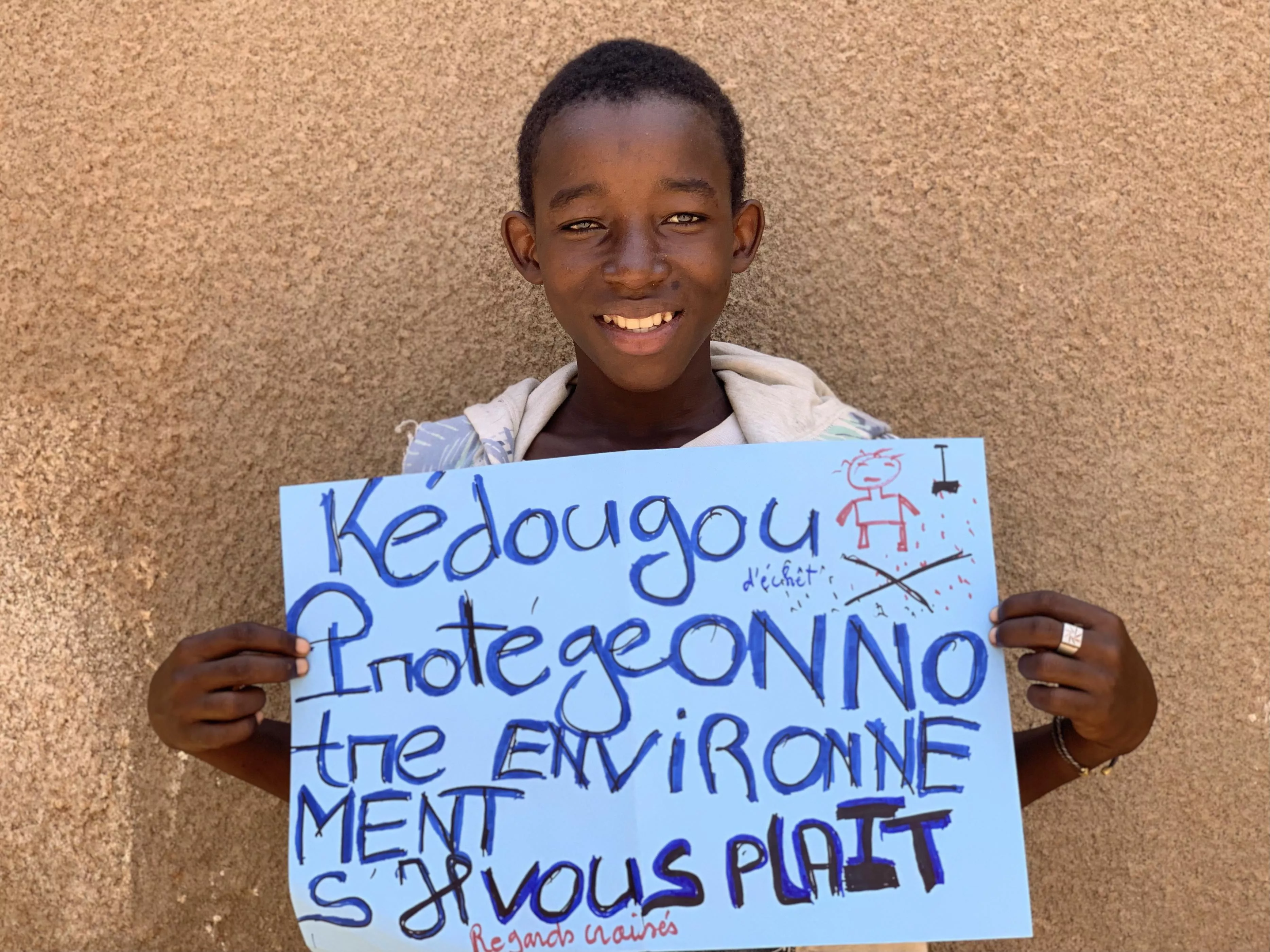 Aliou, un des élèves bénéficiant du programme au collège Maciré Ba à Kédougou, tient dans ses mains l’affiche qu’il a réalisé pour sensibiliser ses camarades. © Tétraktys