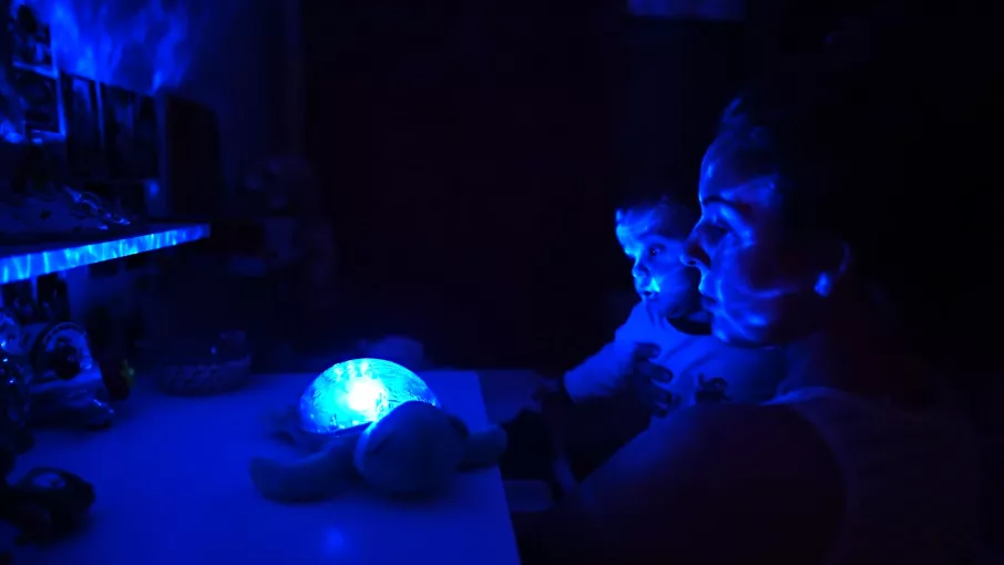 un père et son enfant à la lumière d'une veilleuse bleuté © collectif Fusées - Margot Vicente